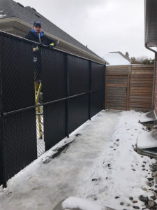 Residential install of a black chain link fence with privacy slats - inside view