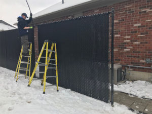 Residential install of a black chain link fence with privacy slats - outside view